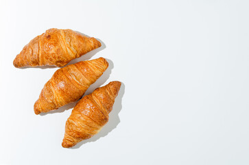 Three fresh croissants isolated on a white background