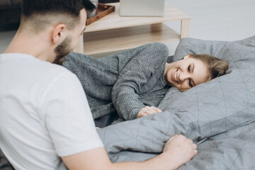 Fototapeta premium Young happy couple in love having fun together in bedroom at home