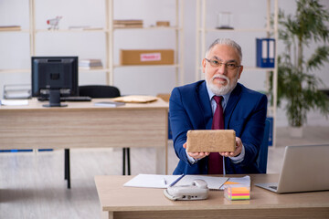 Old male employee ordering box via Internet