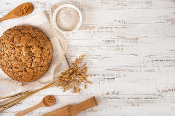 Homemade sourdough bread loaf with rye flour, rye ears and cereal grains. Copy space.