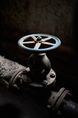 Industrial retro valve or ventil with flanges closeup selective focus over dark industrial...