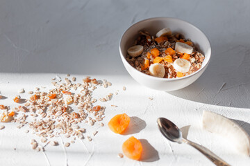 Delicious healthy breakfast with vitamins in the early morning. Muesli on a white table with sun rays