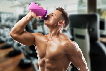 Fitness Supplements. Happy Musculate Man Holding Container With Protein