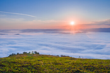 Naklejka na ściany i meble Picturesque sunrise over the sea of fog in the mountains