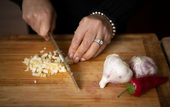Person slicing garlic on the board