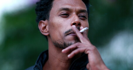 Mixed race portrait man smoking cigarette tobacco outdoors, unhealthy habit