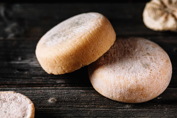 Large heads, natural hard cheese, handmade from goat milk, on a wooden.