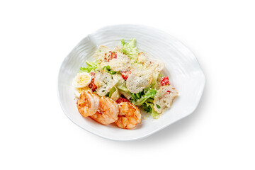 Caesar salad with shrimp in a plate on a white isolated background. Top view, copy space.