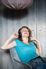 Obraz premium happy relaxed woman with headphones listening to music