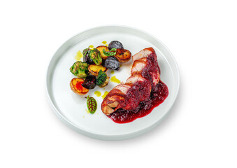 Bacon and pork meat in lingonberry sauce with grilled potatoes, broccoli and beet pieces in a plate on a white isolated background