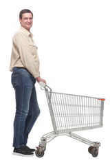 A full length side view portrait of a man pushing an empty shopping cart