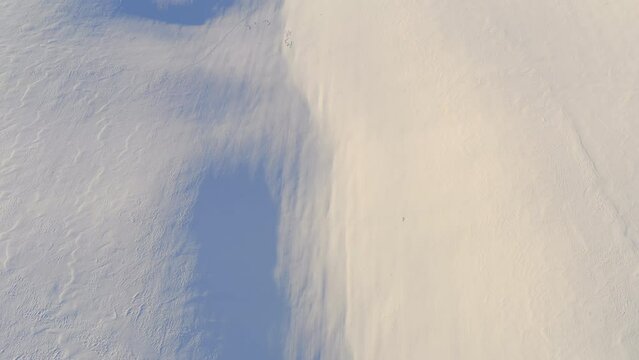 Rescue drone looks for footprints on the snow surface. Rescue operation in the mountains. Search for missing people in winter. Helicopter is looking for traces of border trespassers in the fresh snow.