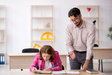Young male teacher and redhead girl in the classroom