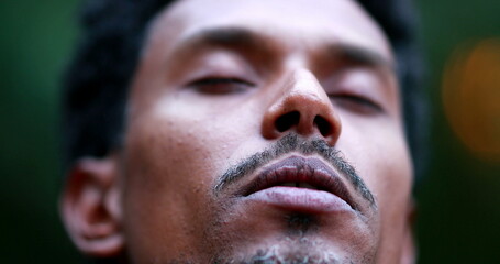 Close-up of man face meditating outside, person exhaling breath outdoors