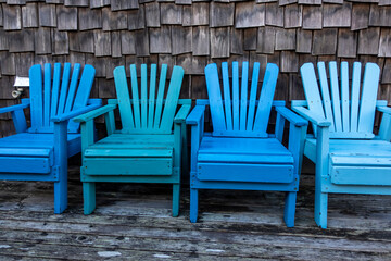 Set of matching blue chairs on a beachfront property patio on a clear day