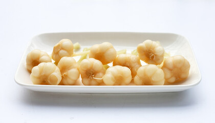 Pickled garlic in plate on white background.