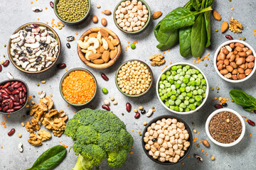 Vegan protein source. Legumes, beans, lentils, nuts, broccoli, spinach and seeds. Top view on stone table. Healthy vegetarian food.