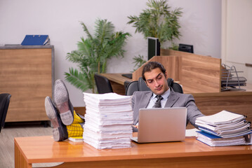 Young male employee and too much work in the office