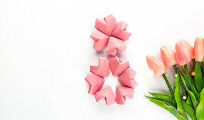 rose-color paper hearts shape figure eight 8 and tulip flowers background. International Women’s Day celebrate on March 8, congratulatory CARD.