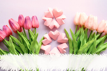 rose-color paper hearts shape figure eight 8 and tulip flowers background. International Women’s Day celebrate on March 8, congratulatory CARD.