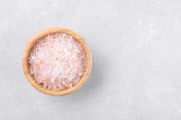 pink himalayan salt in a wooden bowl on a light grey background, copy space, top view, flat lay, view from above - obrazy, fototapety, plakaty