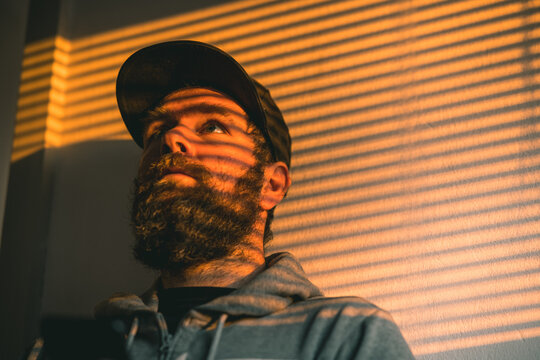 Portrait of a bearded hip guy with beard with shadow stripes of