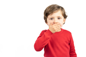 Portrait of a boy in a red sweater with his hands over his mouth