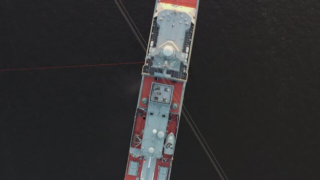 Aerial morning urban landscape with warships in the waters of the Neva River before the holiday of the Russian Navy, sea power, drone flies up around, ship is moored