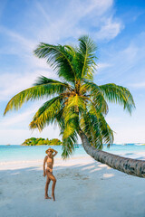 Woman enjoys a tropical beach in Seychelles. Blue sky and sunny day at Maldives beach. Rear view full length shot