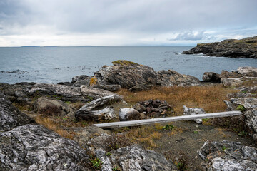 Gorgeous view of the grassy, rocky coastline on San Juan Island on a bright, sunny day with puffy...
