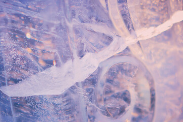Fragment of an ice figure in the rays of the sun. Christmas natural pattern. Refraction, reflection...