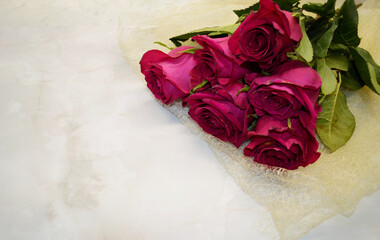 Bouquet of red roses lies on white marble background