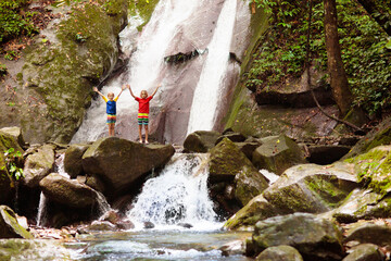 Family with child at waterfall. Travel with kids.