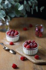 Italian dessert panna cotta with raspberries on wooden background.
