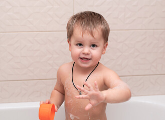 happy little boy bathes in the bathtub. Close-up. Soft focus. The concept of child care.