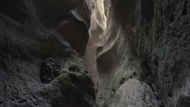 A walk inside the mountain. Action. People walk inside the mountain with huge gray stones.