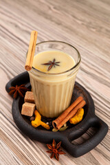 Masala tea or Masala chai in glass, close-up. Popular Indian drink on wooden table