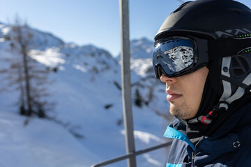 ski resort man on chairlift in helmet and mask