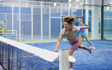 Portrait of a fifteen-year-old guy tennis player engaged in the popular sport of padel with a...