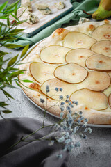 Fruit homemade sweet pear pizza with cheese and honey on a gray stone table. Restaurant Menu