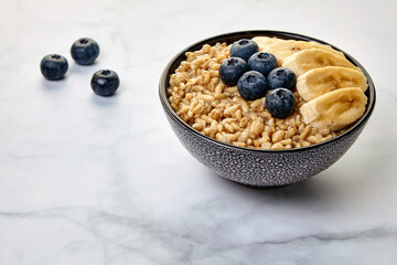 Whole grain oatmeal with flax seeds with blueberries and banana slices