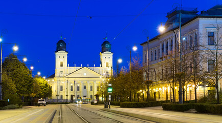 Fototapeta na wymiar Nightlife of illuminated central Debrecen streets with Great Protestant Church, Hungary