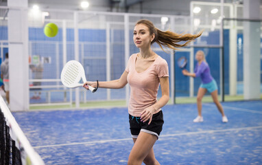 Active sports girl playing padel on the tennis court