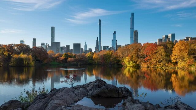 Sunrise on Central Park Lake in Autumn colors with view of New York City Billionaire's Row. Timelapse citiscape of luxury apartment skyscrapers