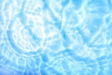 Transparent blue colored clear water surface texture with ripples, splashes and bubbles. Abstract background