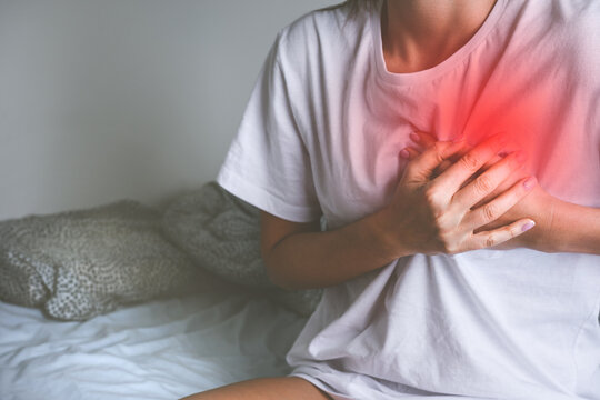 Woman holding chest because of acute heart pain or chest pain. Heart disease and heart attack symptom