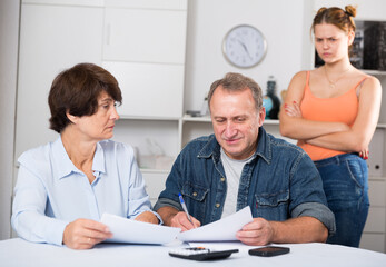 Obraz premium Adult couple is singing contract with their daughter indoor.