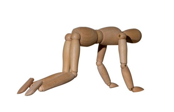 wooden mannequin stands on all fours, performs physical exercise, isolated on white