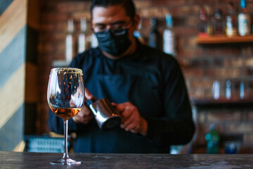 Bartender preparing a drink on a glass