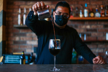 Bartender preparing a drink on a glass